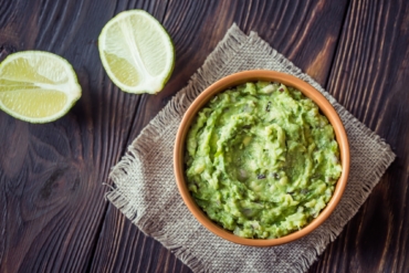 Bowl of guacamole on the wooden table