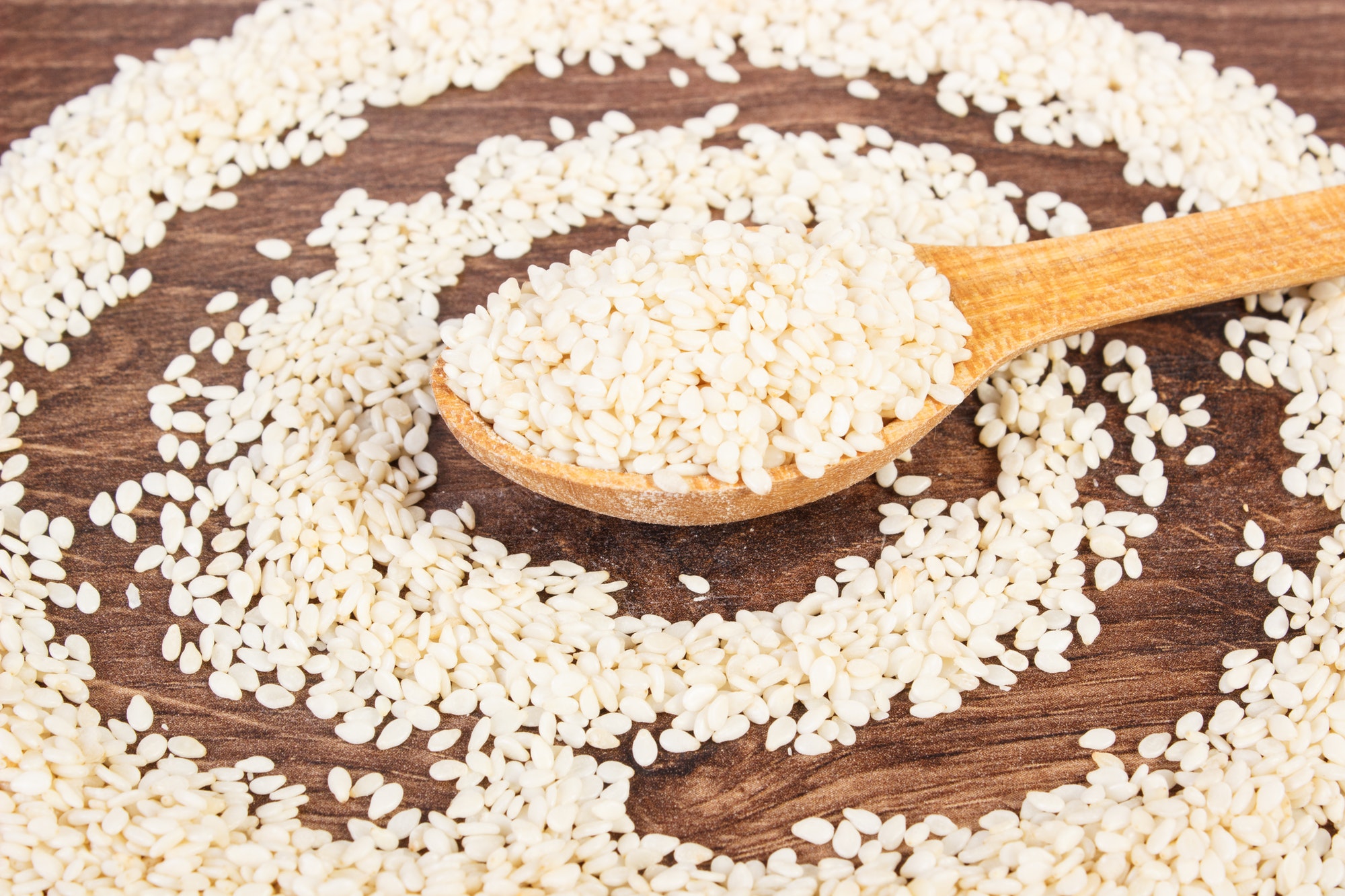 Sesame seeds with wooden spoon