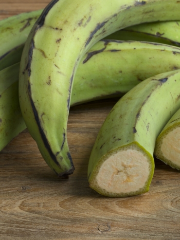 Whole and half green unripe bananas